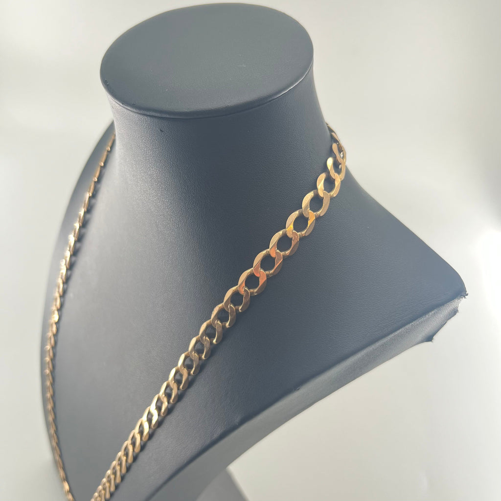 CB STORES yellow gold curb chain necklace with flat oval links displayed on a black mannequin bust against a light background.