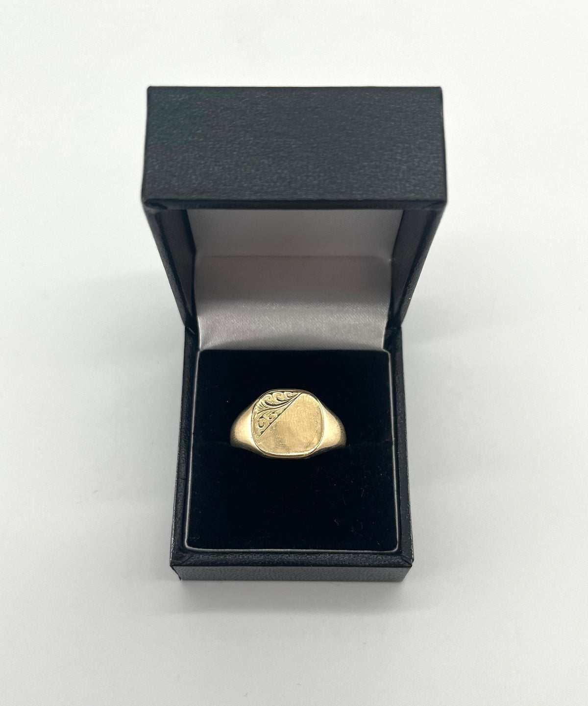 CB STORES 9ct square signet ring, partly engraved, displayed upright in a black ring box with white lining on a plain background.
