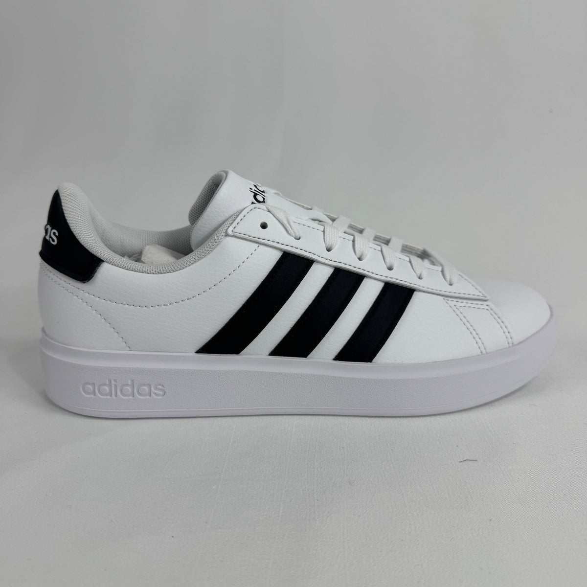 The Adidas Grand Court 2.0 is a casual court-inspired sneaker with a smooth synthetic or leather-like upper, soft