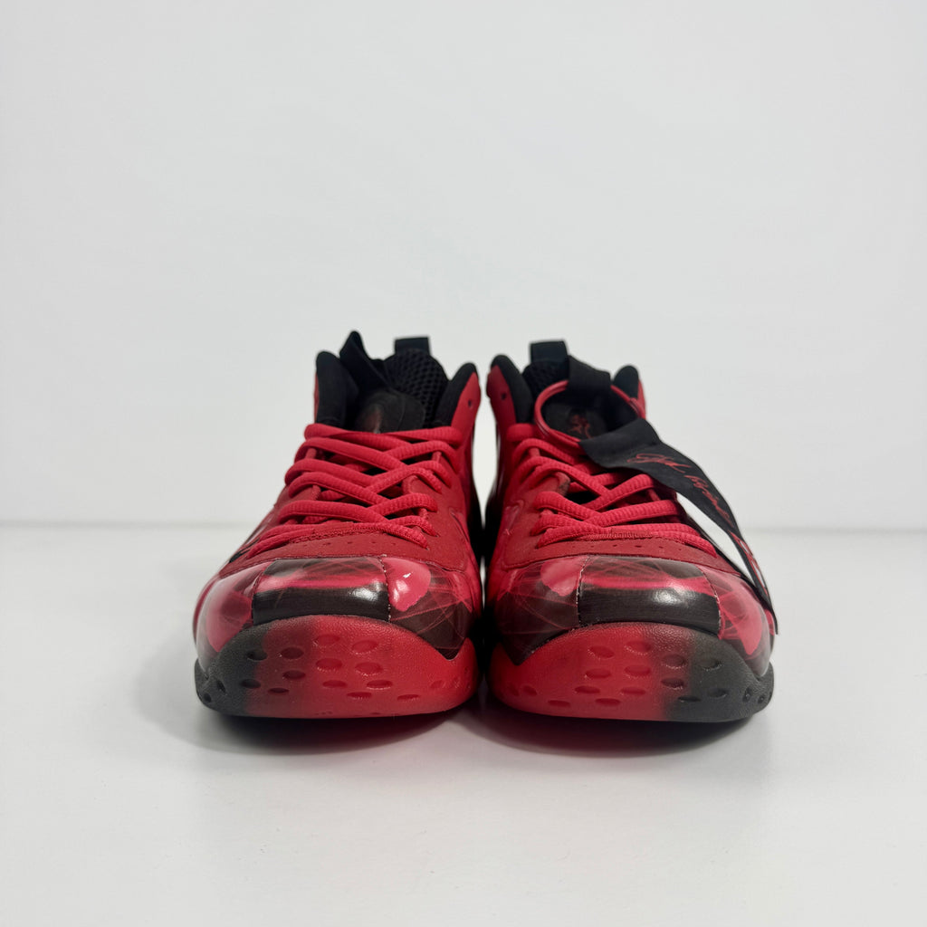 Nike trainers with red and black accents displayed side by side on a white surface with a plain white background.