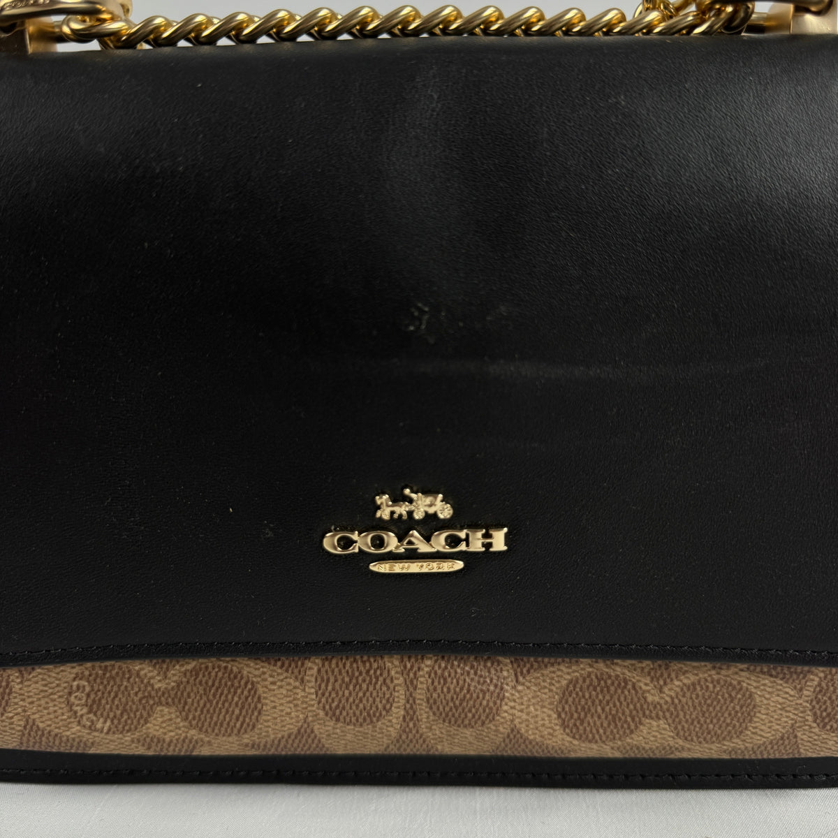 The Coach Klare Crossbody Bag is a structured leather bag with a flap closure, signature hardware, and an adjustable strap,