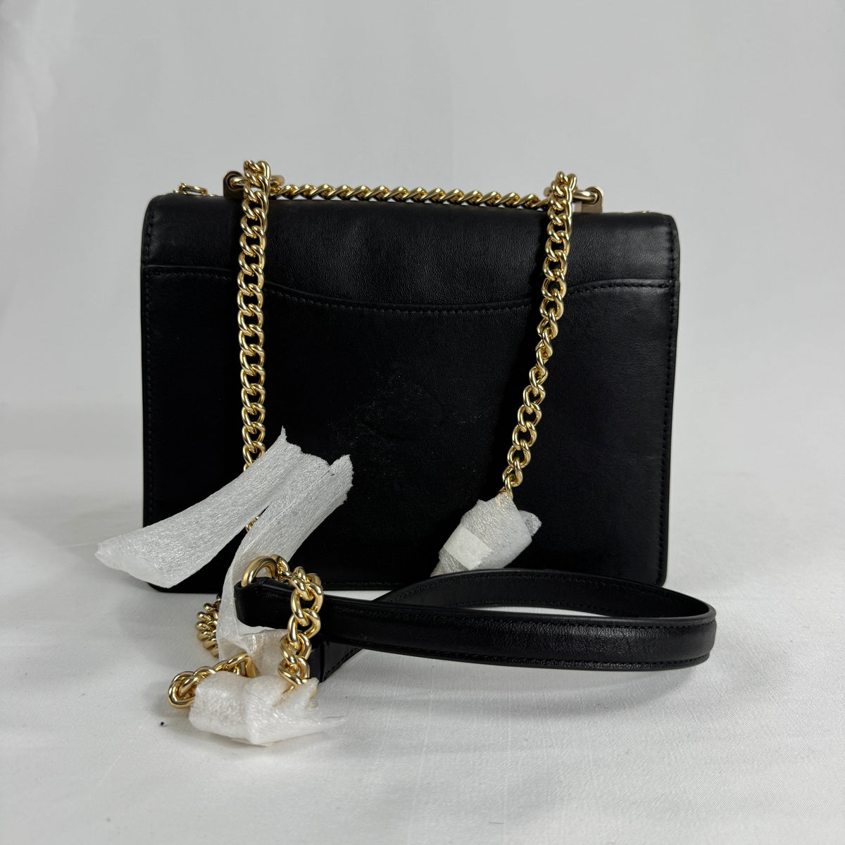 The Coach Klare Crossbody Bag is a structured leather bag with a flap closure, signature hardware, and an adjustable strap,