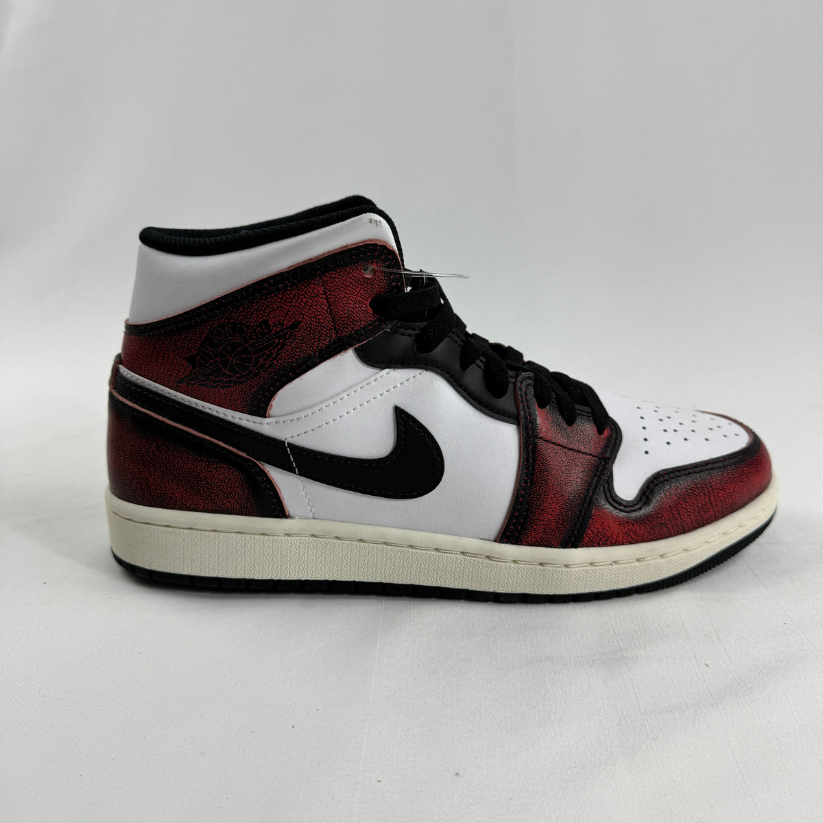 Air Jordan 1 Mid “Wear Away Chicago” is a mid-top sneaker with a white leather base and black overlays that are designed to