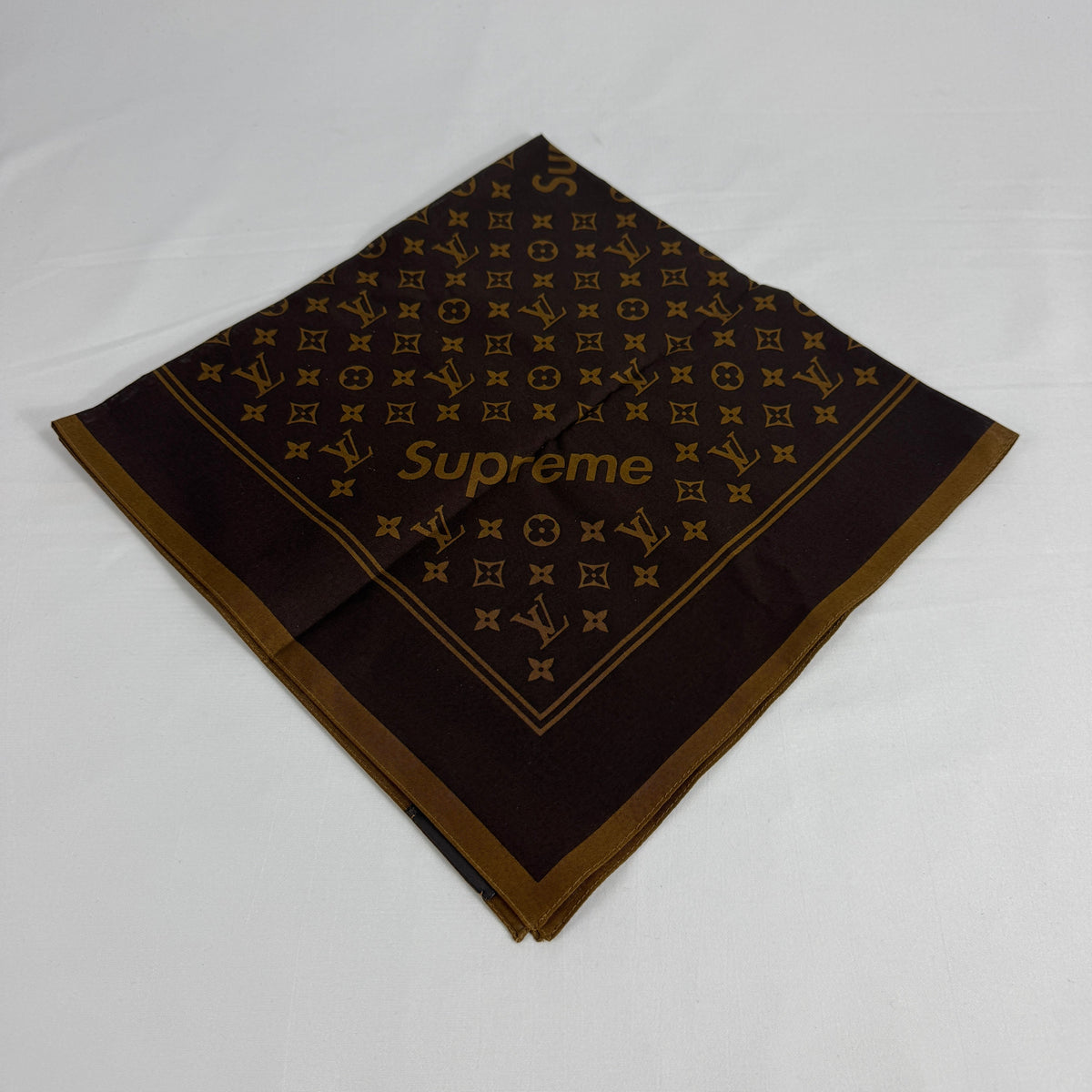 The Louis Vuitton x Supreme headscarf is a rare collaboration accessory featuring luxury silk construction with bold