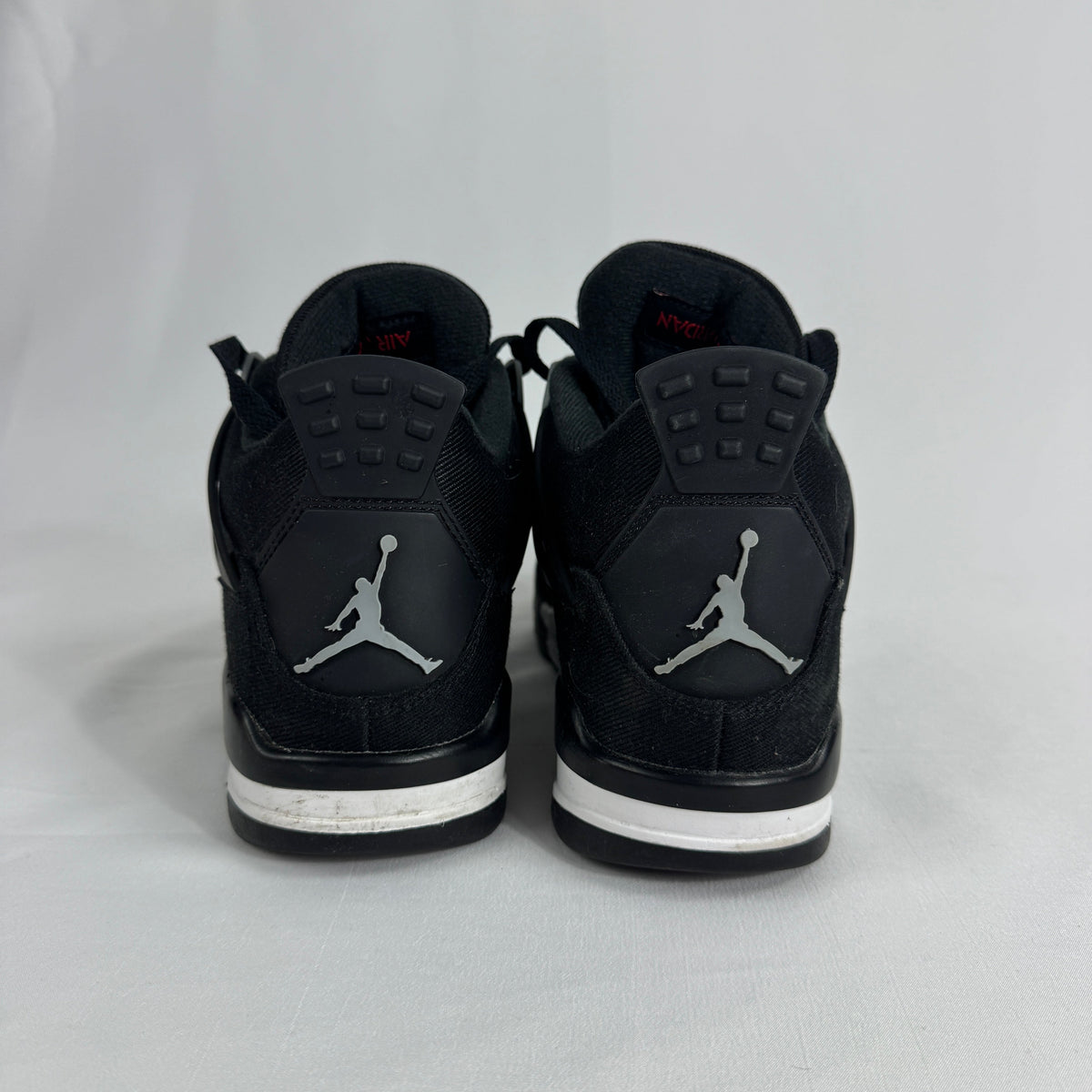 The Nike Air Jordan 4 Black Canvas is a versatile sneaker featuring a durable black canvas upper, suede accents, and