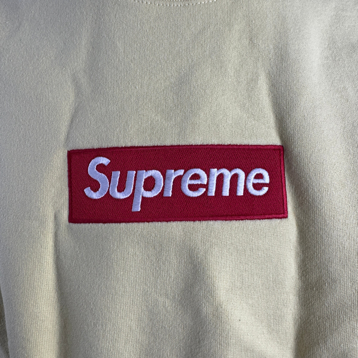 The Supreme Box Logo in pale yellow refers to a signature Supreme piece featuring the iconic box logo graphic set against a