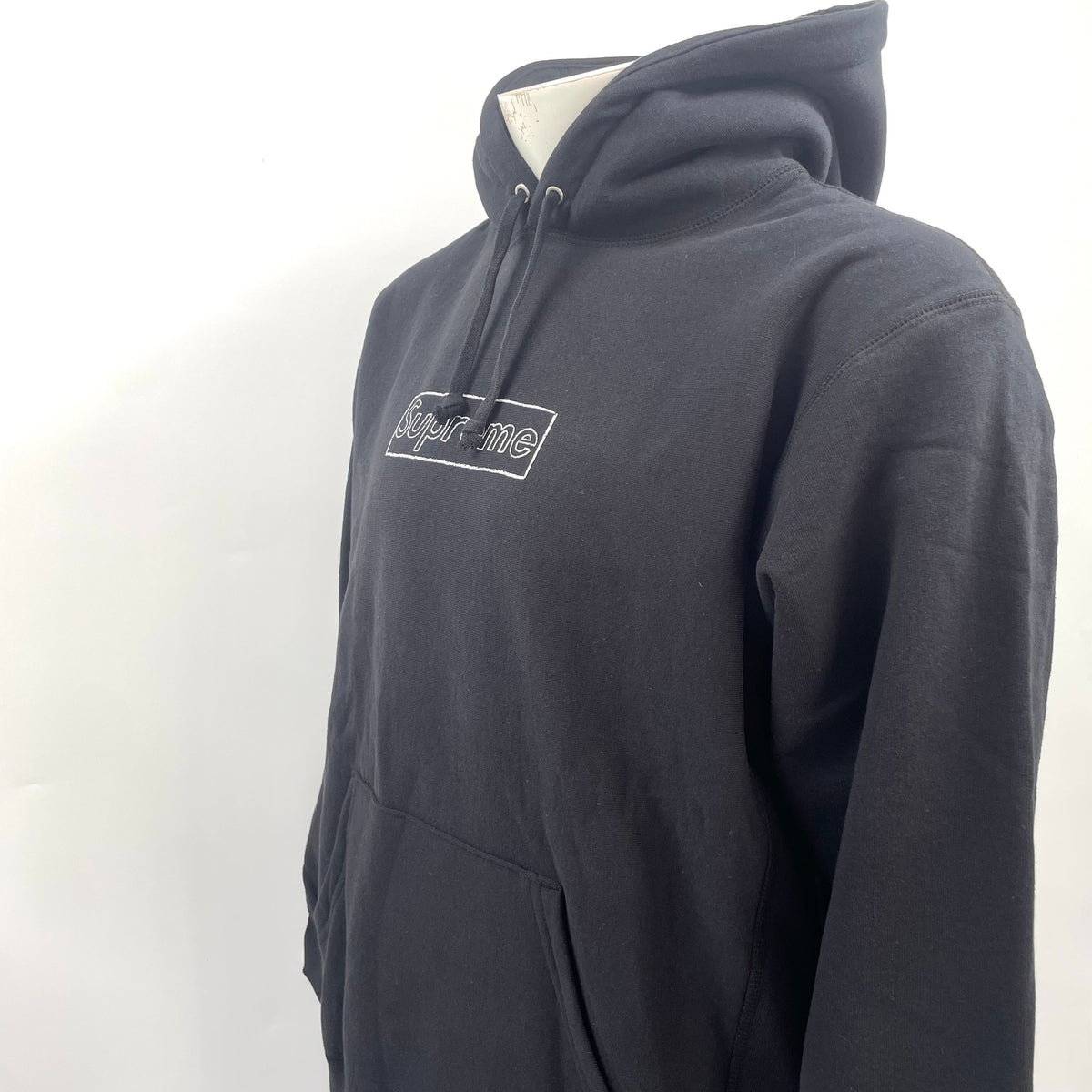 The Supreme KAWS Chalk Hooded Sweatshirt Black is a heavyweight cotton hoodie featuring KAWS’ signature chalk-style Box Logo
