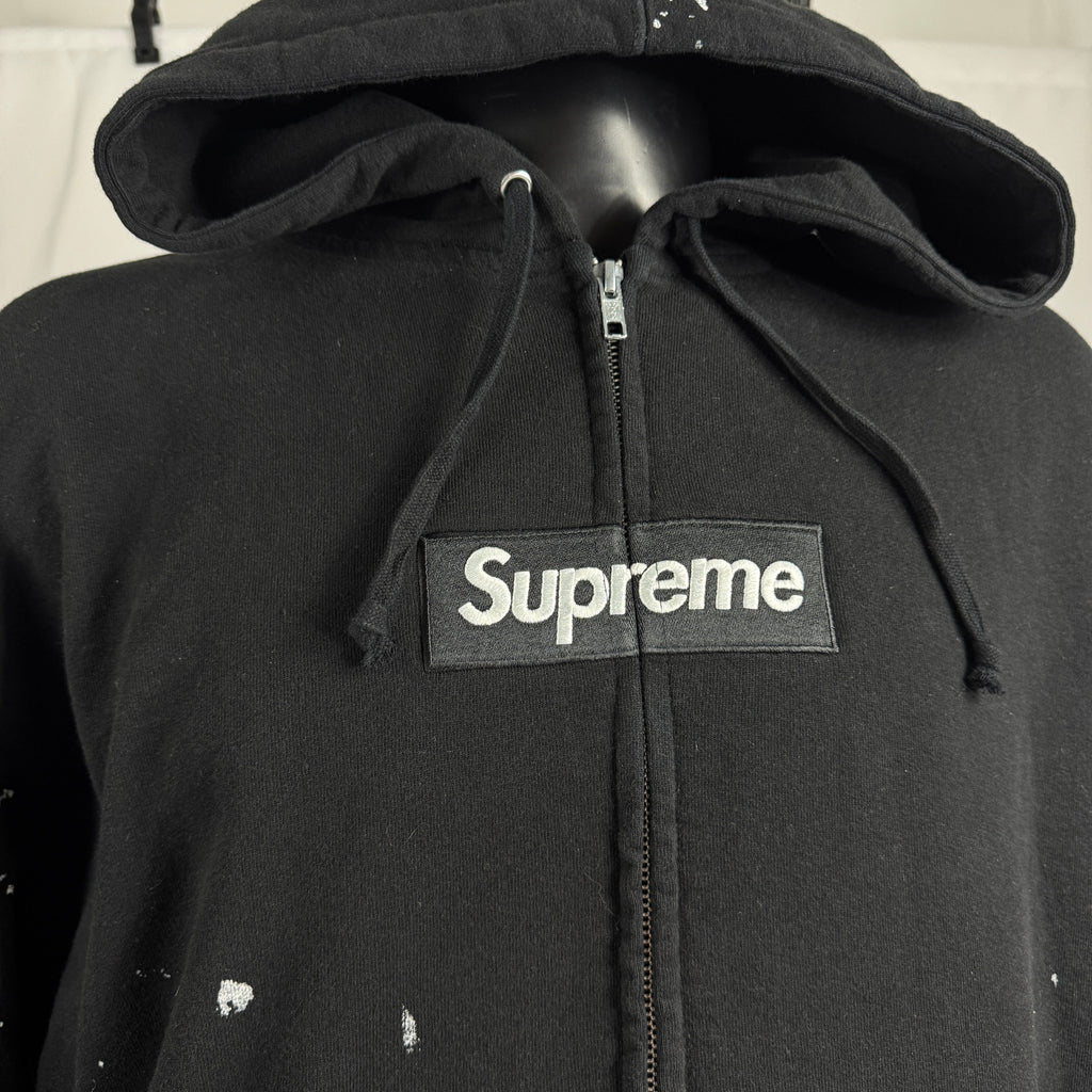 The Supreme x Maison Margiela Box Logo Zip Up is a limited-edition collaboration hoodie featuring Supreme’s iconic Box Logo,